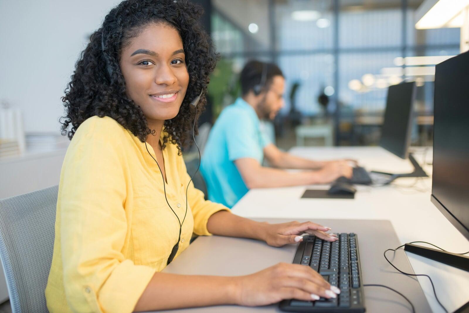 A friendly, bilingual customer service professional at Beninobas Jamaica BPO LLC smiling while wearing a headset, representing our mission to deliver exceptional nearshore sales and technical support."